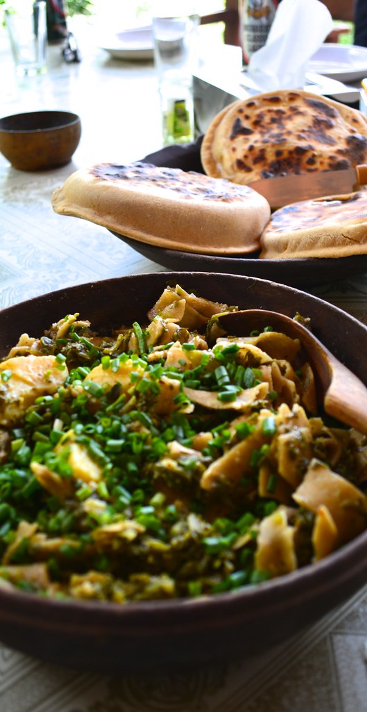 Close-up of Hoi Lo Garma garnished with greens and served with traditional Hunza bread