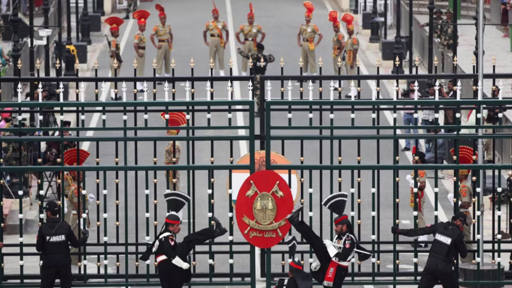Photo of Wagah Border ceremony showing Pakistani soldiers in high-step march with crowd visible behind.