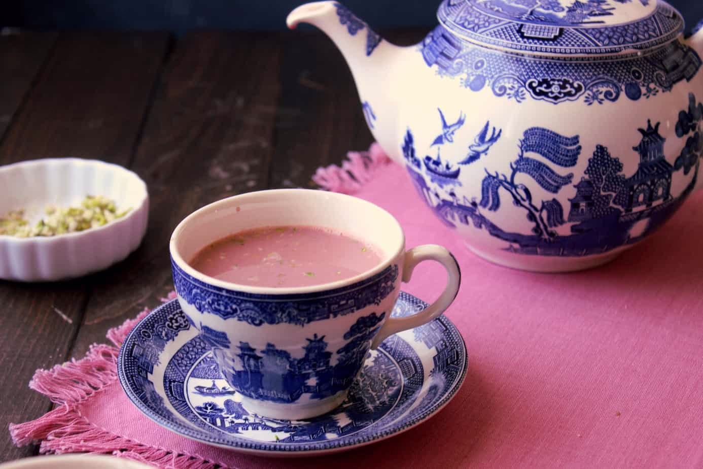 Kashmiri Chai — the distinctive pink tea served in traditional cups with a dusting of crushed pistachios on top.